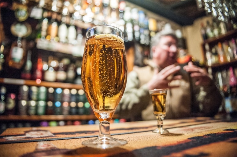 Na posnetku je videti trenutek, ko gost odloži polno pivo na rob mize in se oddalji. V naslednjih sekundah se kozarec, kot bi ga potisnila nevidna sila, počasi premakne proti robu, nato pa zgrmi na tla in se razbije. Fotografija je simbolična. 