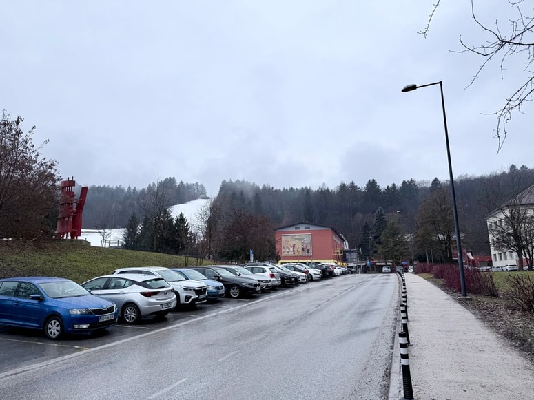 Parkirišče pred parkom, Gimnazijo, Srednjo šolo Ravne in DTK.