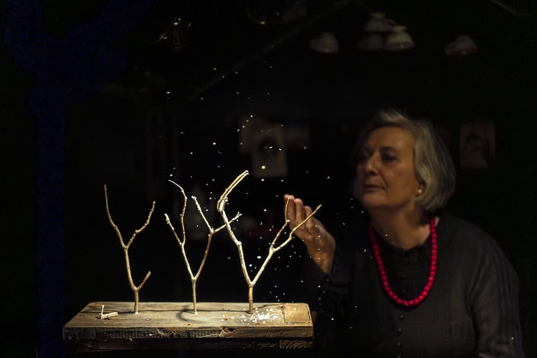 Igralka in animatorka Metka Jurc v subtilno osvetljeni predstavi 