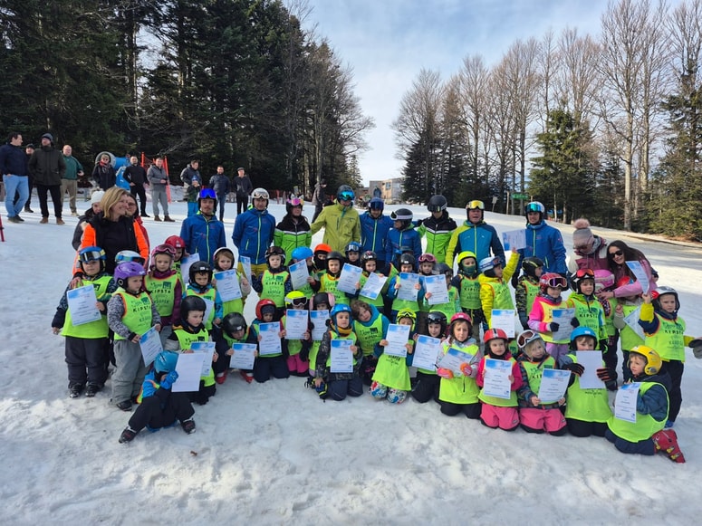 Otroci, ki obiskujejo Vrtec Hoče z učitelji smučanja in vzgojiteljicami.
