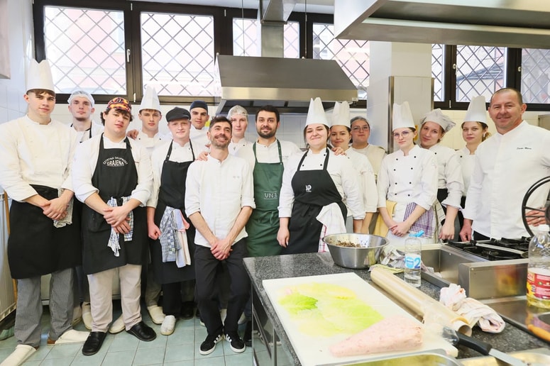 Guglio Gigli (v zelenem predpasniku) s pomočnikom Fabiem Fortijem (stoji pred njim) ter z dijaki in učitelji, ki so pripravljali italijansko kosilo za goste. 