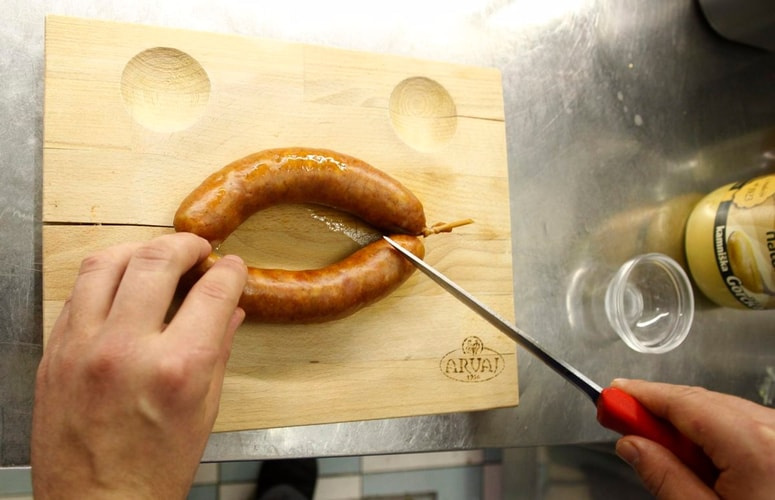 V klobasi se je skrival štirimilimetrski košček kosti. Fotografija je simbolična. 