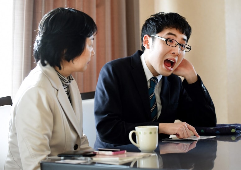 Japonski avtor Naoki Higašida (desno) je tudi intervjuje ob izidu knjige opravil tako, da je kazal na posamezne črke in znake, napisane na papir.  