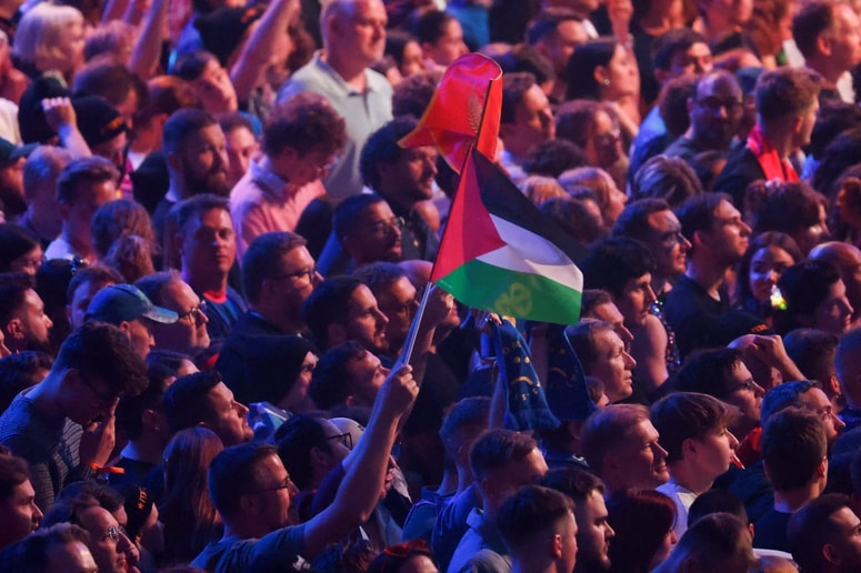 Obiskovalec drži palestinsko zastavo. 