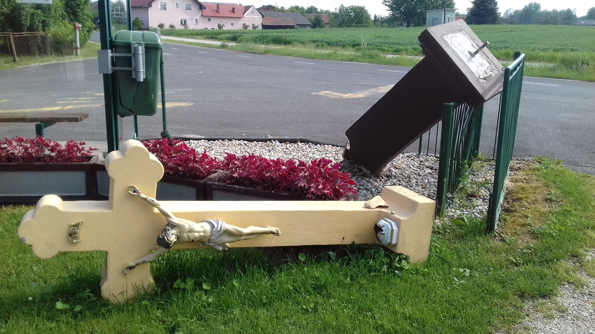 Križ iz 18. stoletja leži razlomljen ob cesti