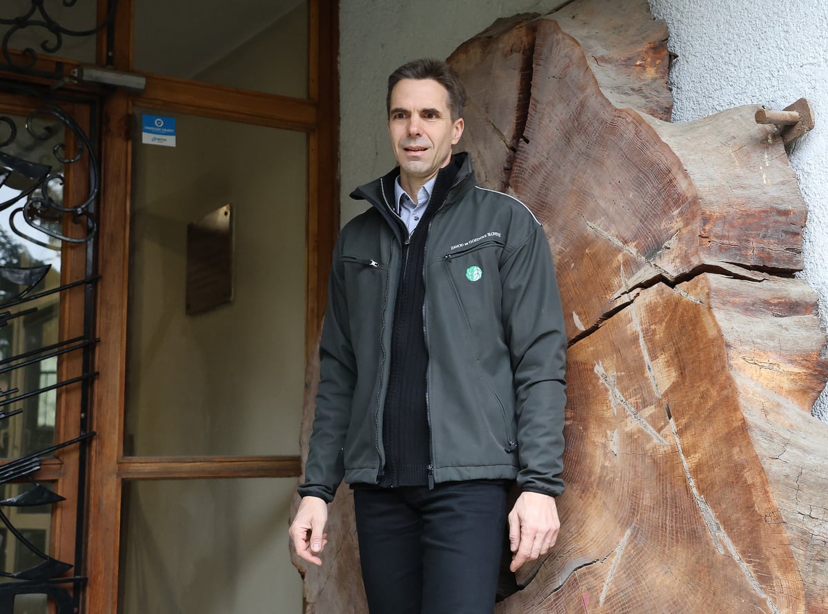 Igor Kopše ob starem hlodu, ki ga v enoti razumejo kot del svojega DNK in simbol gozdarske tradicije hiše na Tyrševi ulici. Kos lesa, star domnevno med 200 in 250 let, želijo ob selitvi obnoviti in vzeti s seboj kot simbol hiše in gozdarske tradicije. 